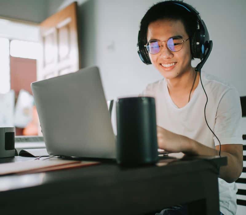 virtual assistant wearing headphones working on his laptop